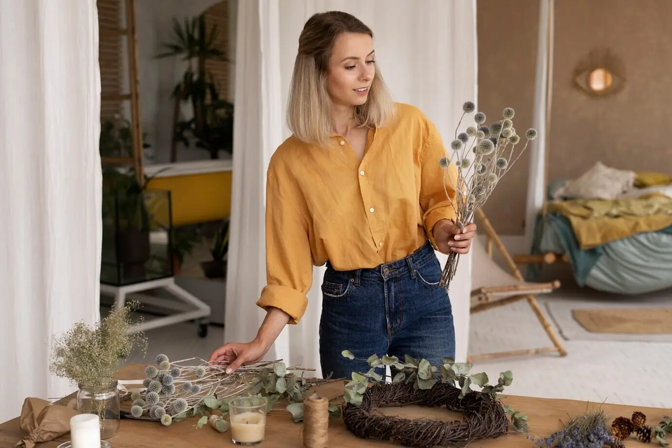 Eine Frau stellt ihr eigenes Arrangement aus getrockneten Blumen zusammen.